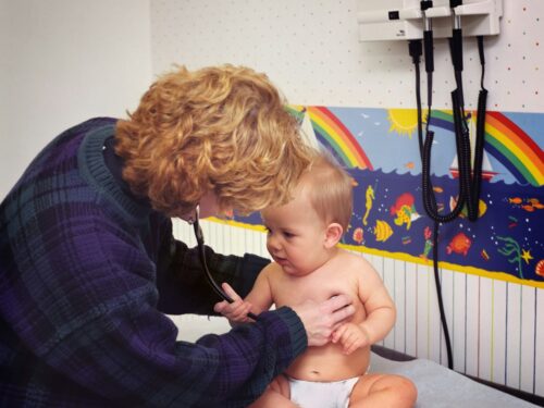 a woman with a stethoscope examines a baby's chest