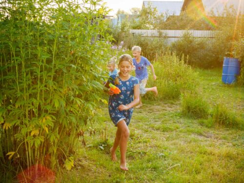 girl in blue and white shirt standing on green grass field during daytime