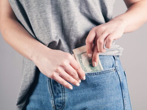 person in gray shirt and blue denim jeans holding blue denim jeans