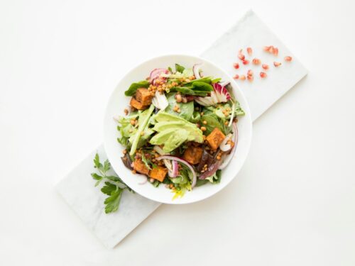 cooked food with sliced vegetables in white bowl