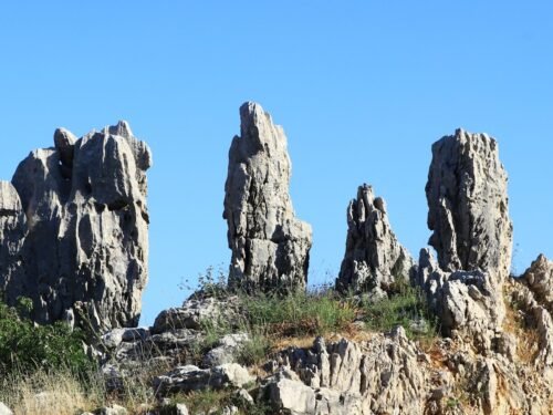 Rocky mountain peaks stand tall under a clear sky.