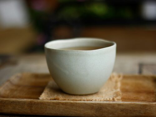 white ceramic cup on brown wooden table