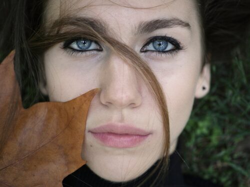 woman in black shirt with brown leaf on her face