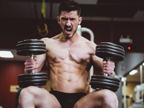 man holding two dumbbells