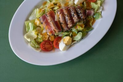 a white plate topped with a salad and meat