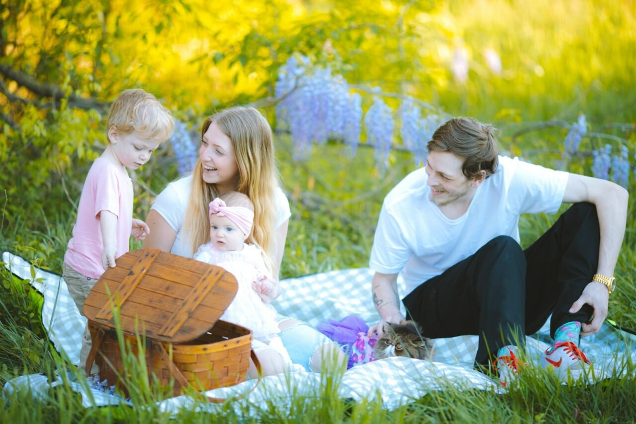a family sitting on a blanket in the grass