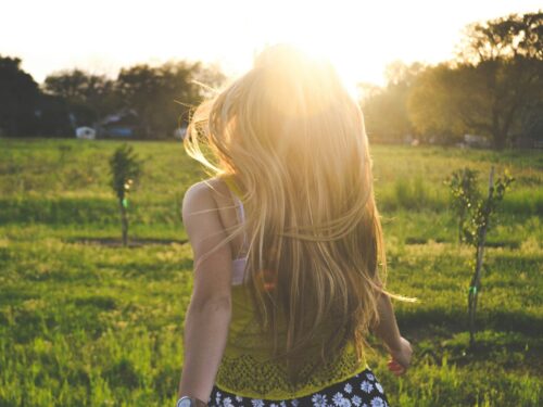 woman walking on lawn with trees