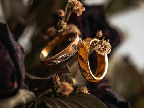 gold wedding band on brown leaves