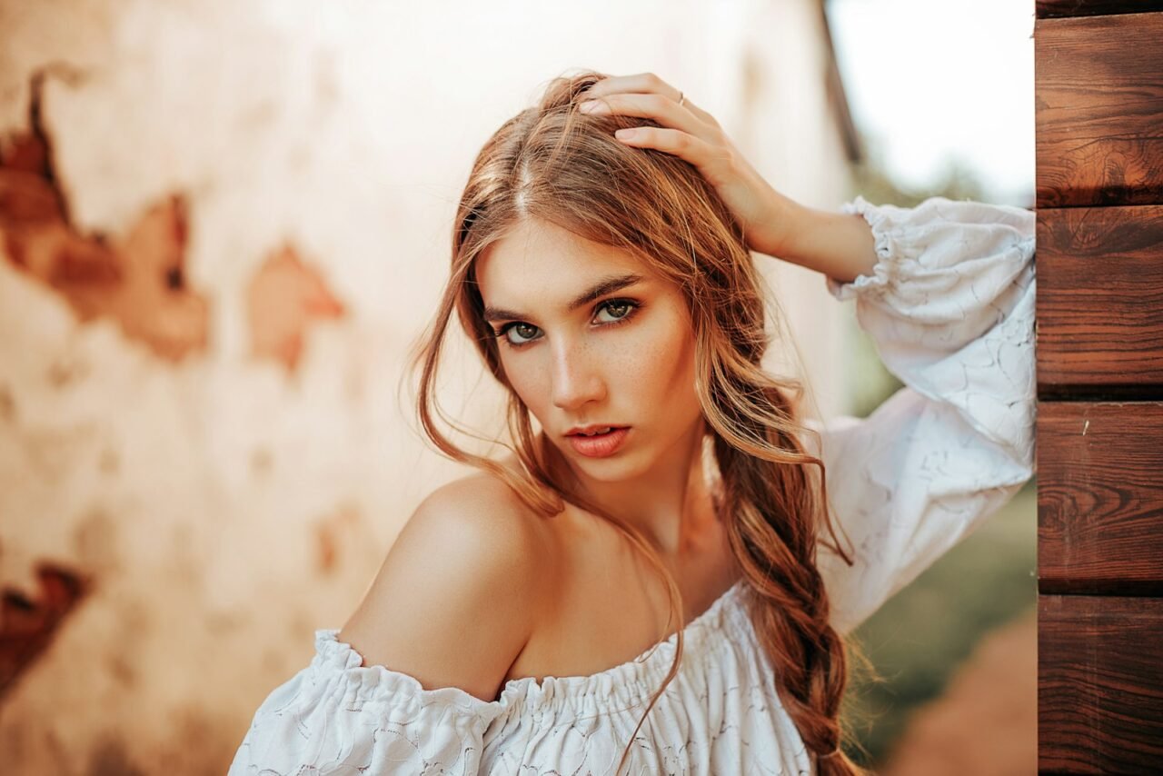 a woman with long hair wearing a white top