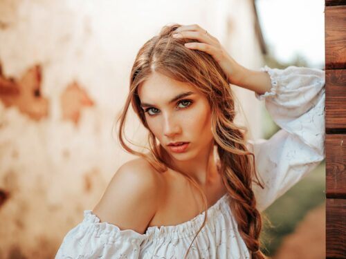 a woman with long hair wearing a white top