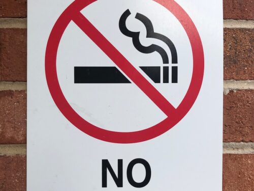 a no smoking sign on a brick wall