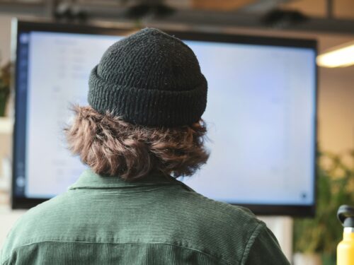 person in green shirt wearing black knit cap