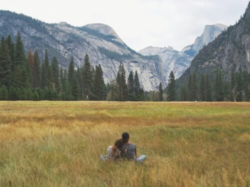 two person sitting on grass field
