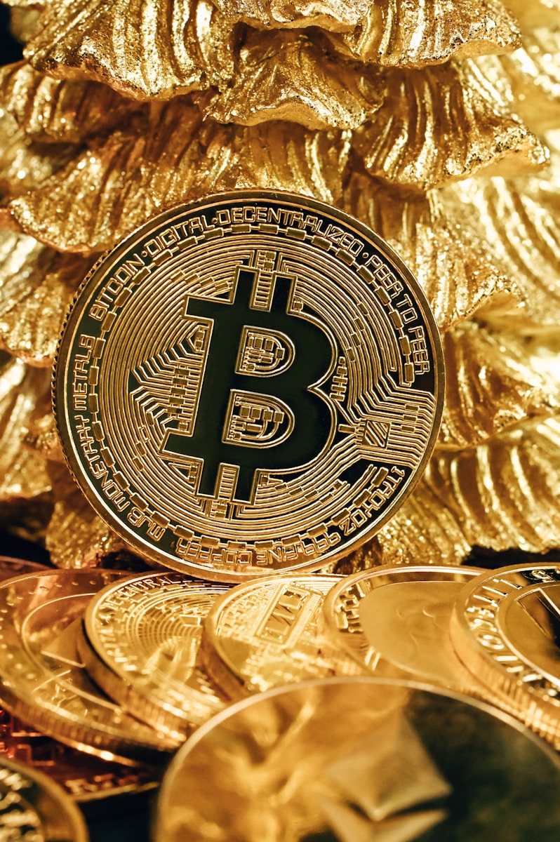 a bitcoin sitting on top of a pile of gold coins