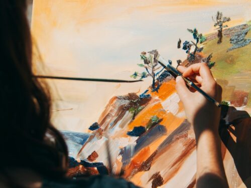 woman painting tree and cliff