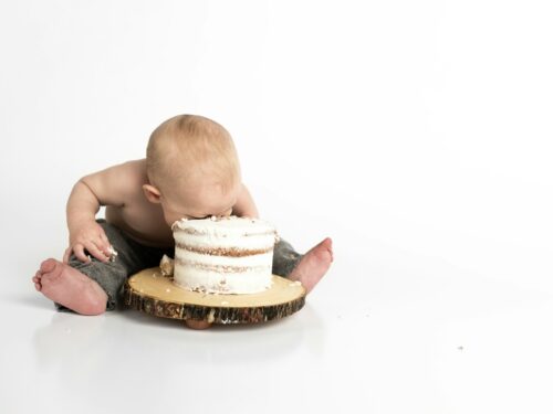 kid sitting beside round cake close-up photography