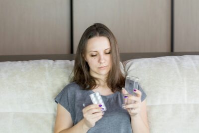 a woman sitting on a couch looking at her cell phone