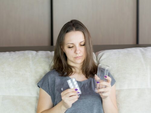 a woman sitting on a couch looking at her cell phone