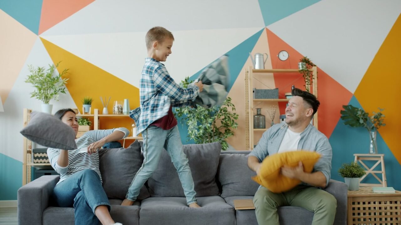 Family having a pillow fight on the couch