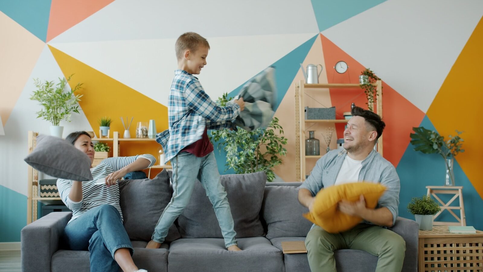 Family having a pillow fight on the couch