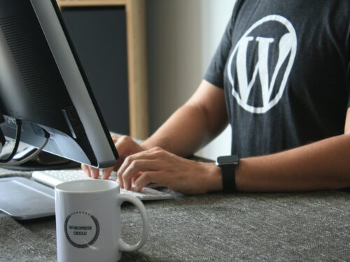 person in black and white t-shirt using computer